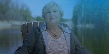 Image shows a woman (Lynn) sitting in a chair smiling.